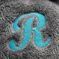 Embroidered monogram close-up on plush poncho